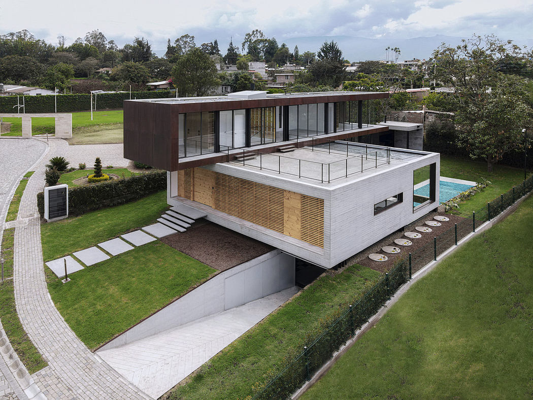 Modern two-story house with large windows, a flat roof, and a pool,