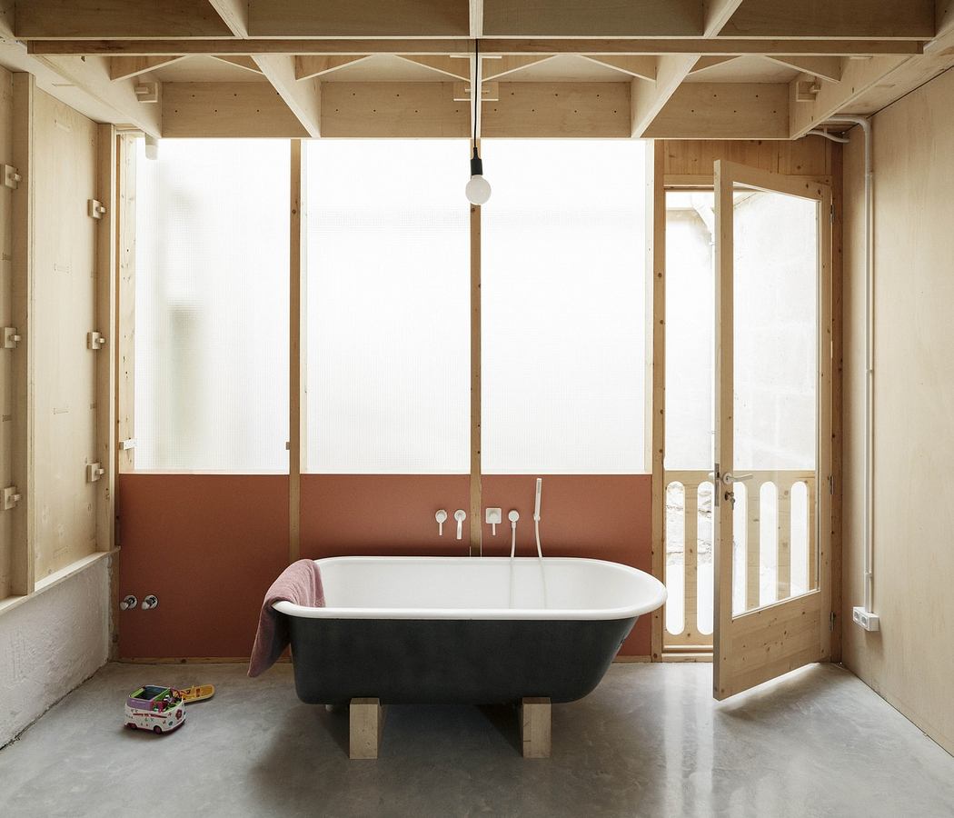Minimalist bathroom with a freestanding tub and exposed wooden beams.