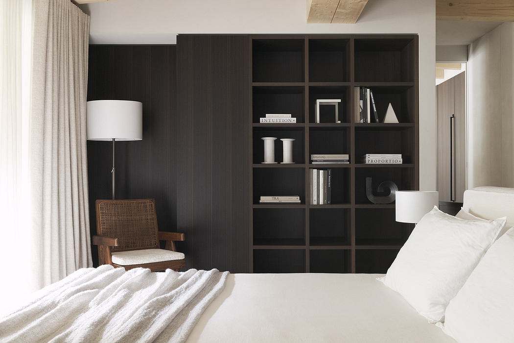 Modern bedroom with a large bookshelf, armchair, and floor lamp.
