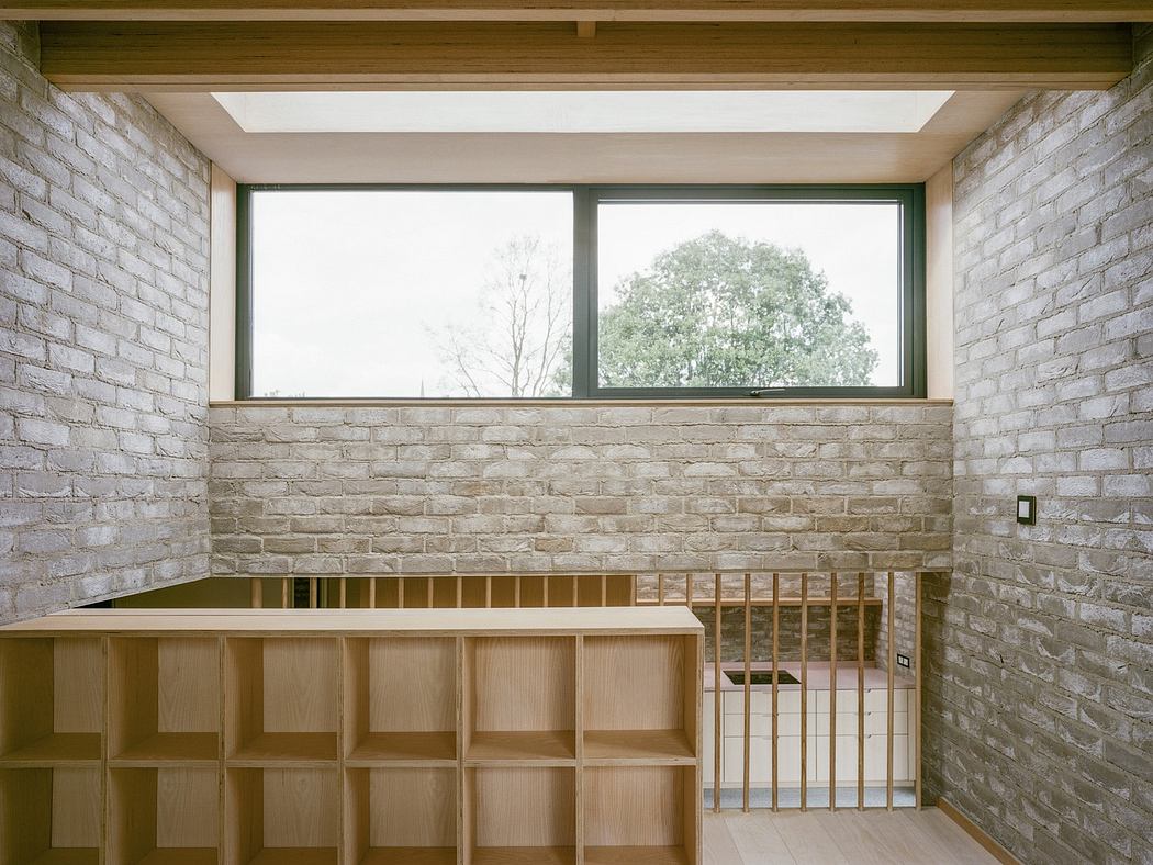 Minimalist room with bare brick walls, wooden shelves, and a large window.