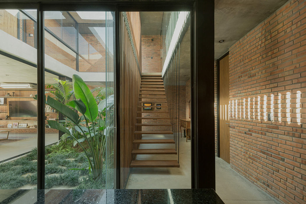 Contemporary hallway with brick walls, wooden staircase, and glass details.
