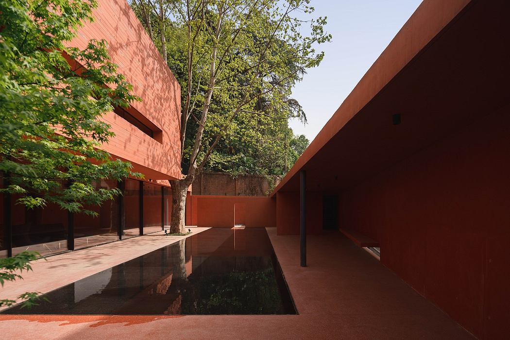 Minimalist courtyard with terracotta walls and reflecting pool.