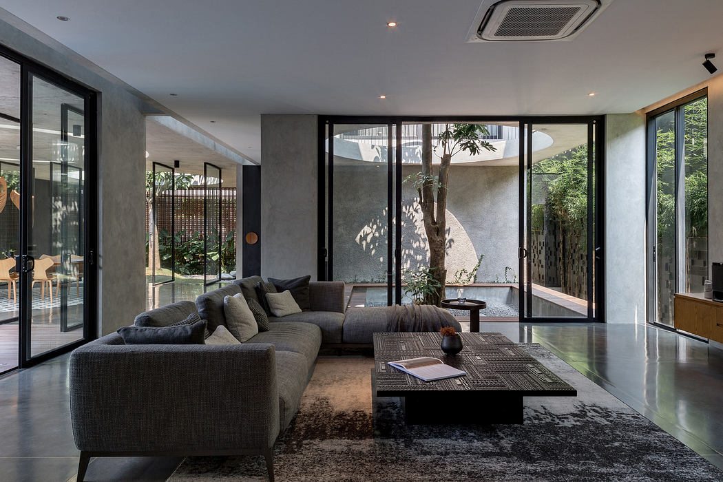 Modern living room with large windows, concrete walls, and minimalist furniture.