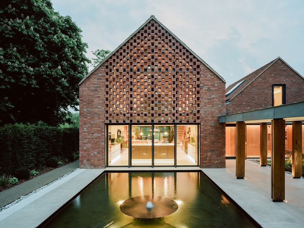 Contemporary brick house with large windows overlooking a reflective pool.