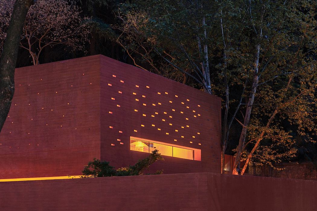 Contemporary terracotta building with patterned facade lighting at dusk.