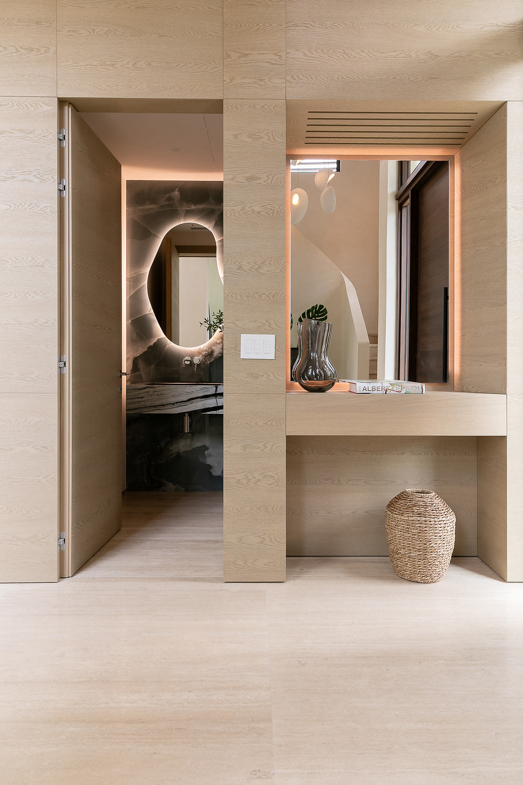 Modern interior with wooden finishes, minimalist desk, and decorative mirror.