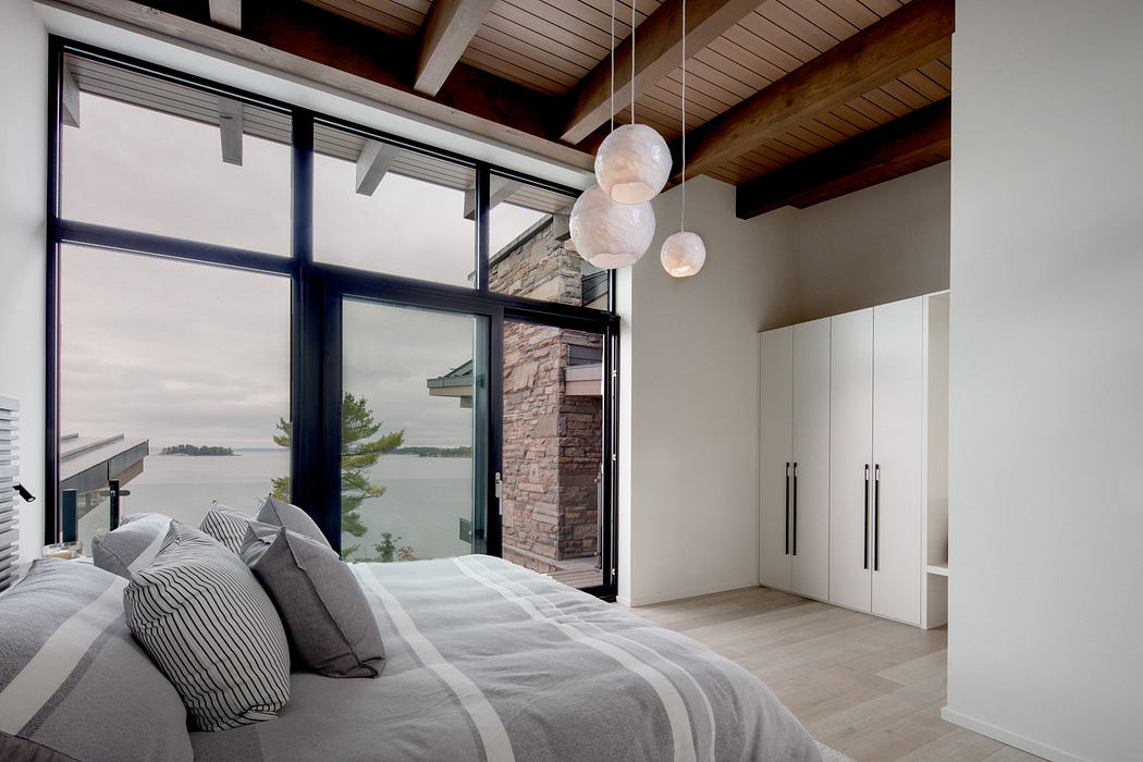 Contemporary bedroom with large windows and lake view.