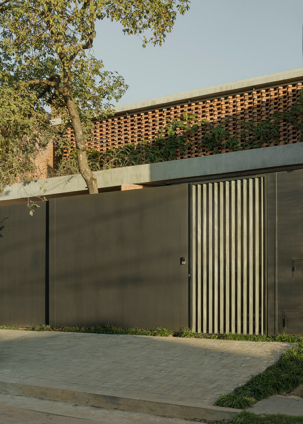 Contemporary wall with vertical slat gate and brickwork detailing.