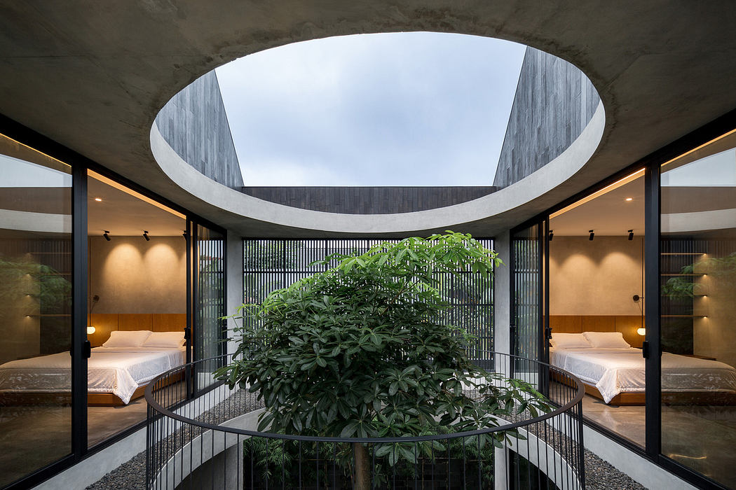 Modern interior courtyard with a circular skylight, greenery, and symmetrical