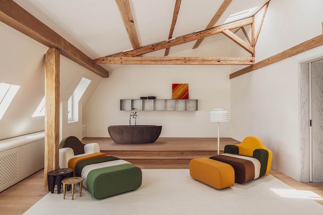Modern minimalist interior with exposed beams, colorful furniture, and freestanding bathtub.