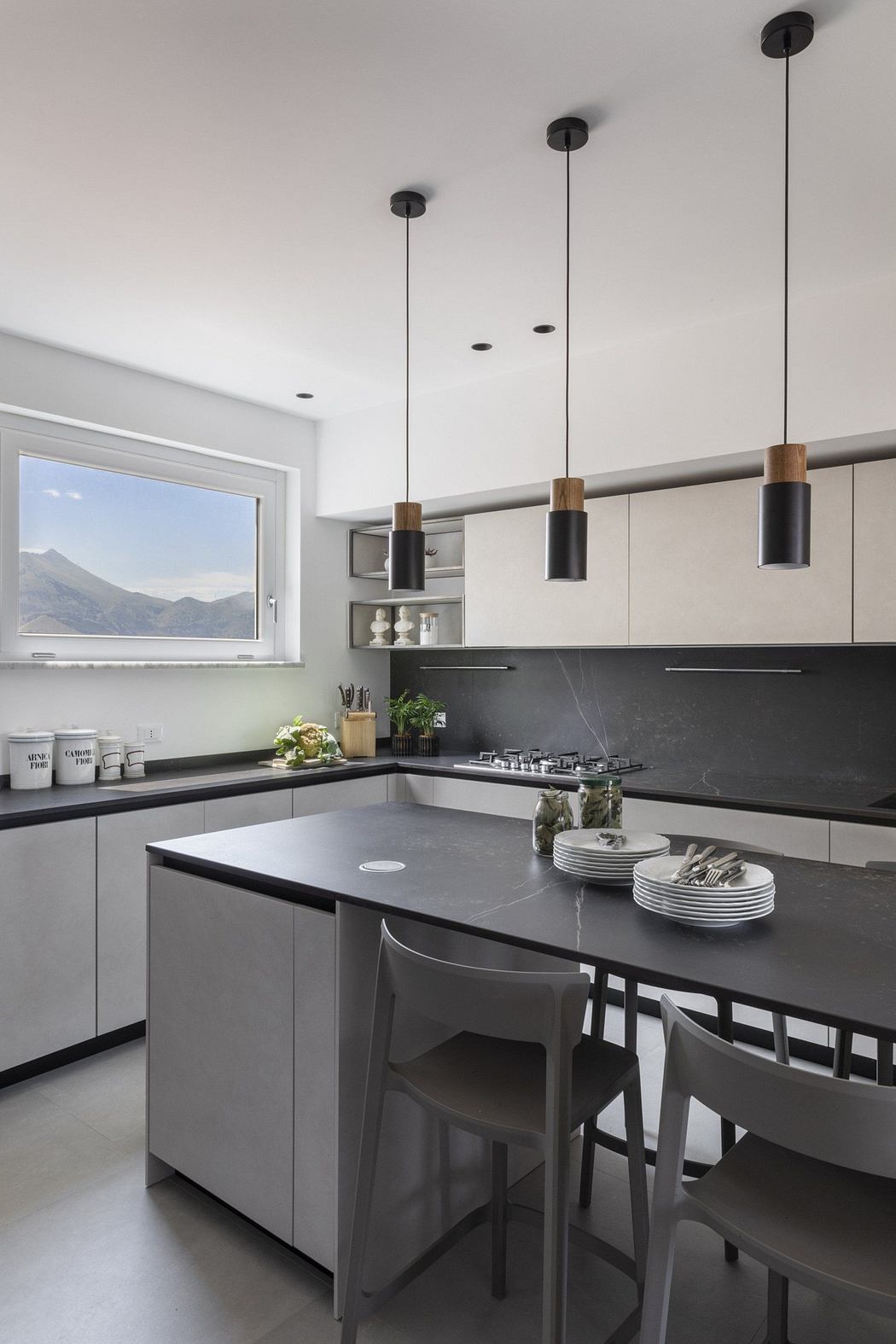 Sleek kitchen with pendant lights and mountain view.