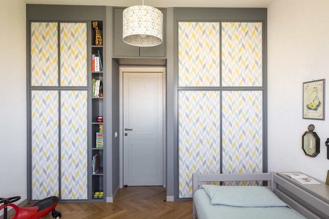 Contemporary room with geometric-patterned wardrobe doors, drum light, and minimalist decor
