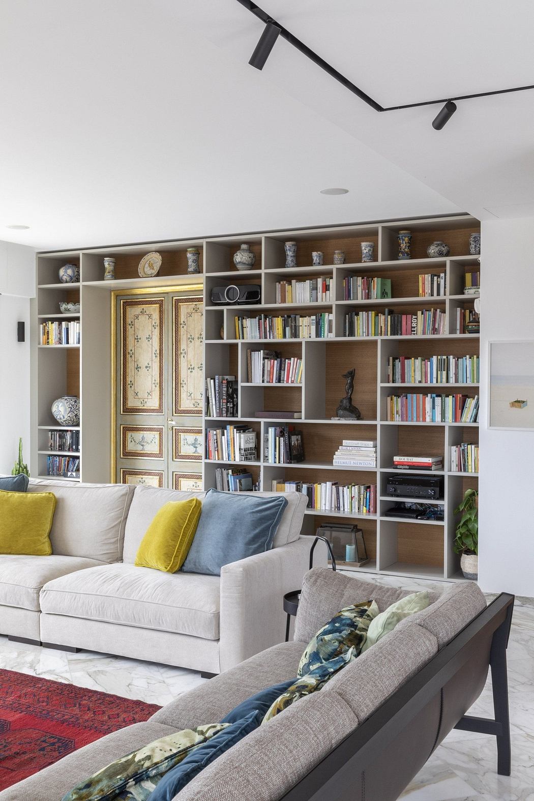 Contemporary living room with large bookshelf and cozy seating.
