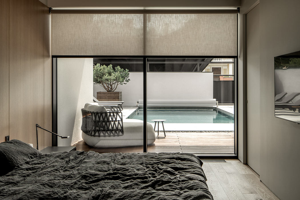 Minimalist bedroom with large window overlooking a pool