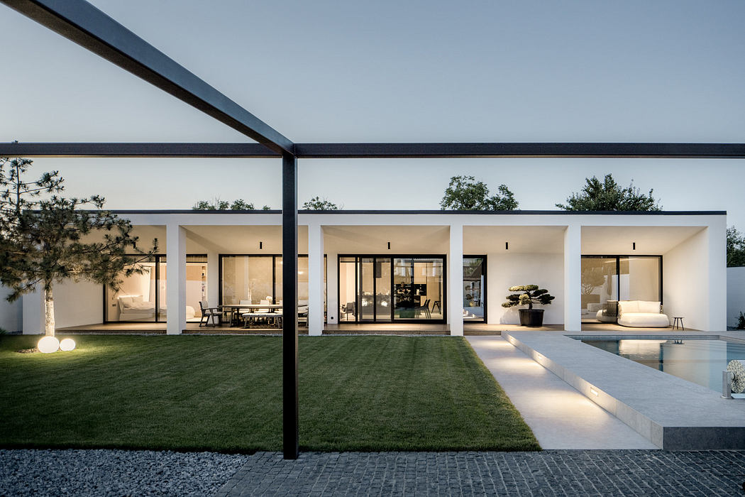 Minimalist white house with large windows and flat roof.