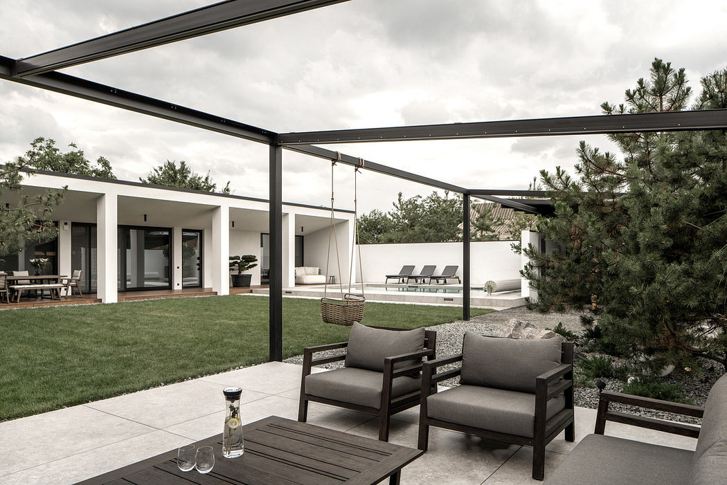 Contemporary patio with minimalist furniture and open lawn view.