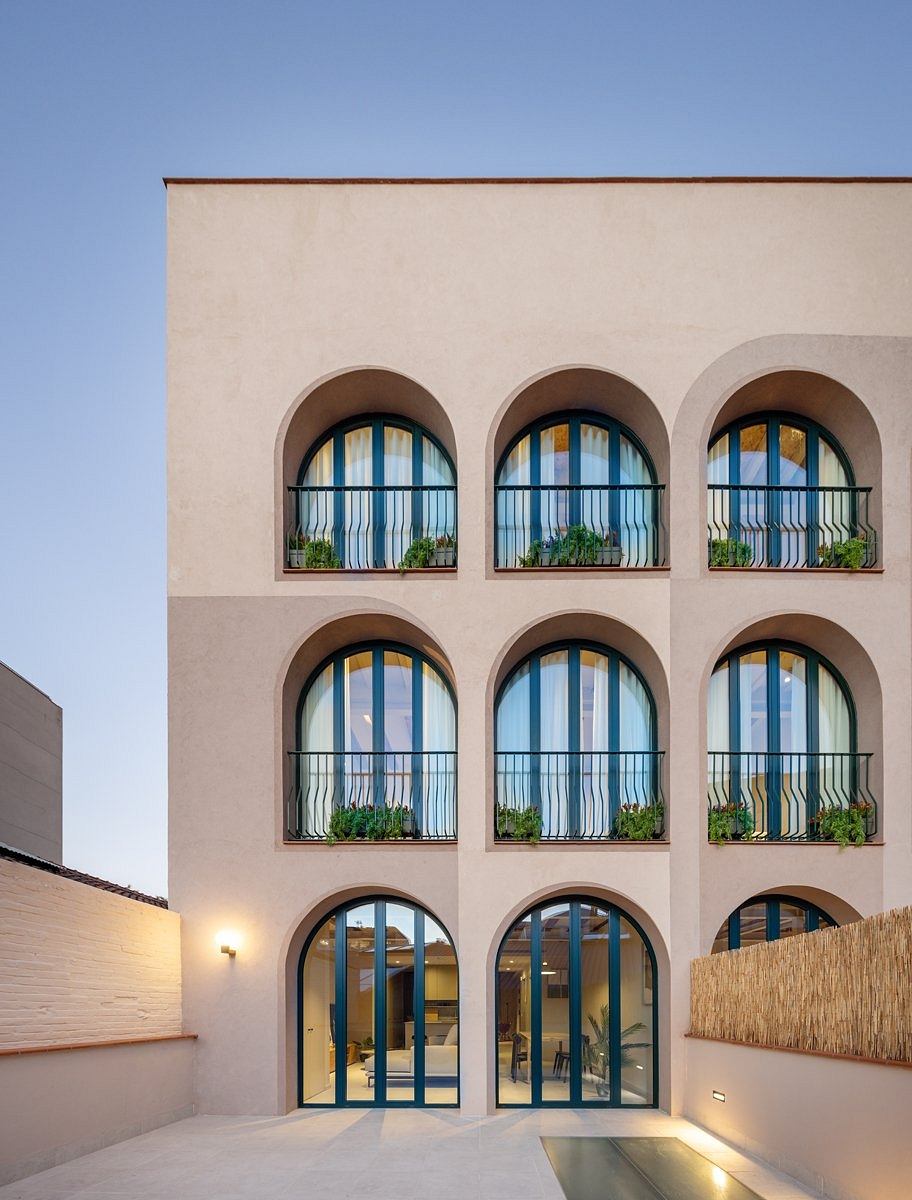 Ornate arched windows, balconies, and a minimalist, modern entryway design.