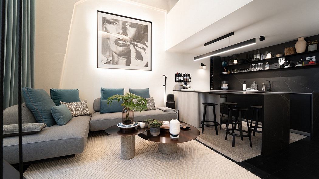 Modern living room with gray sofa, coffee table, and kitchenette with bar stools