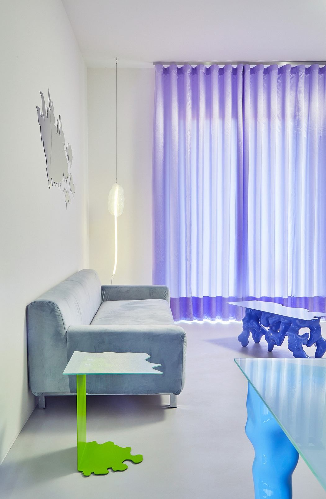 A modern and colorful living room with a gray couch, vibrant curtains, and playful decor.