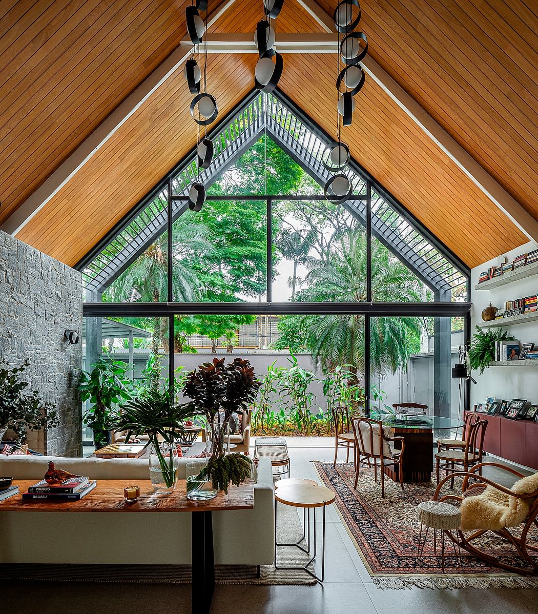 Airy room with high ceilings, exposed beams, large windows, and lush green