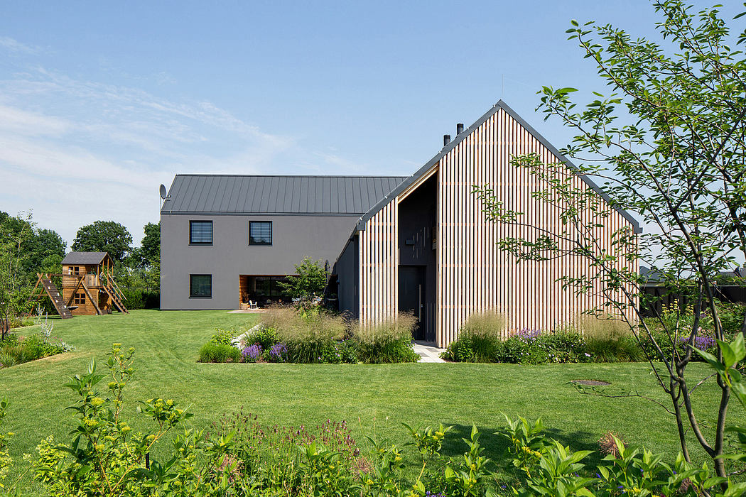 Contemporary houses with slanted roofs and wooden facade amidst a lush garden.