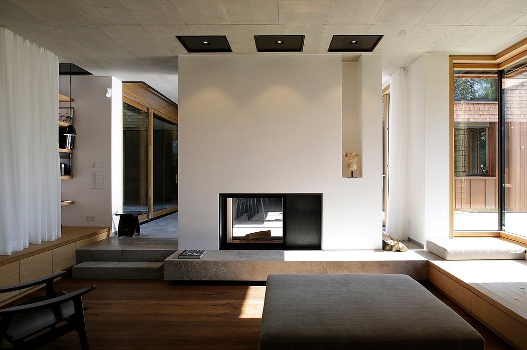 Minimalist living room with a fireplace, large windows, and wooden accents.