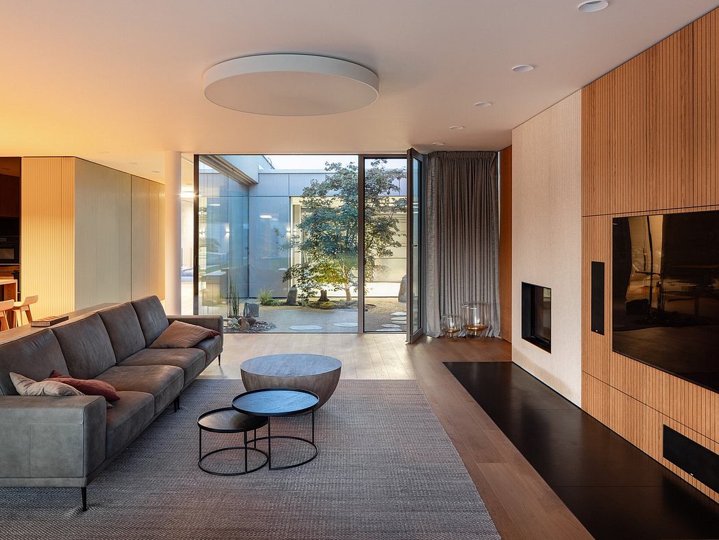 Contemporary living room with wood paneling and large windows.