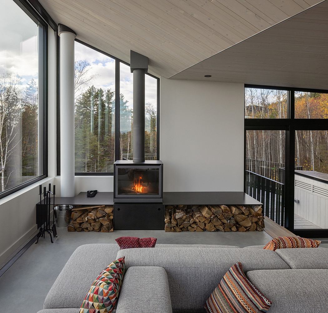 Contemporary living room with a freestanding fireplace and forest view.