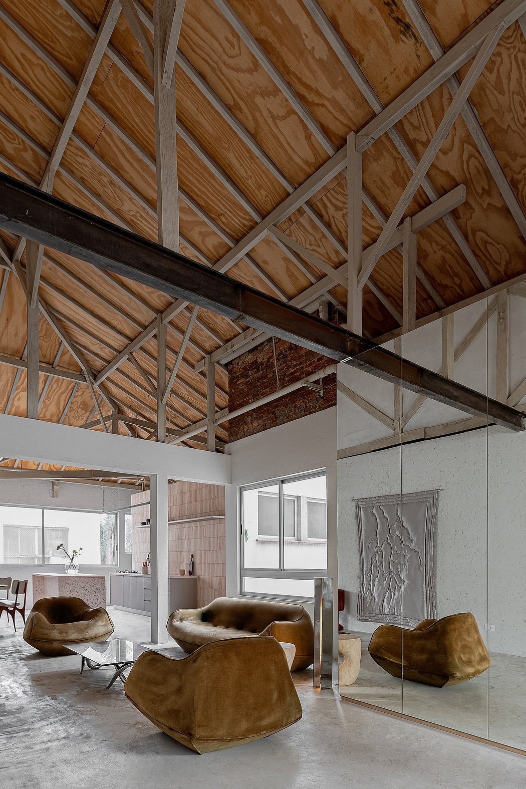 Industrial chic loft with exposed wooden beams and velvety chairs.