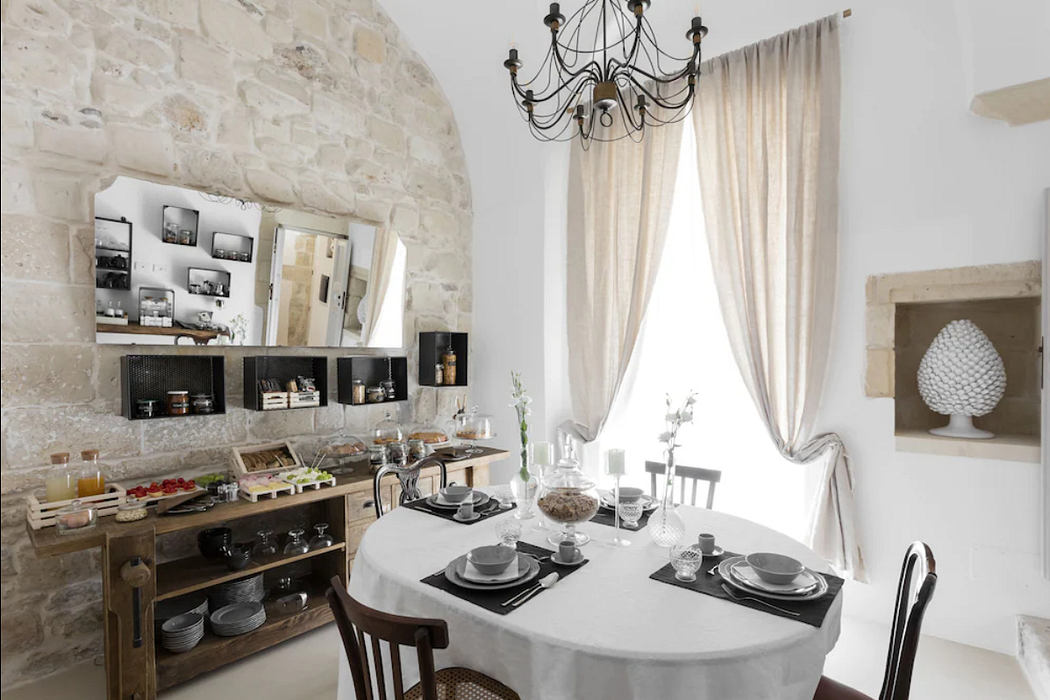 Rustic stone walls, elegant chandelier, and well-designed kitchenette in this cozy space.