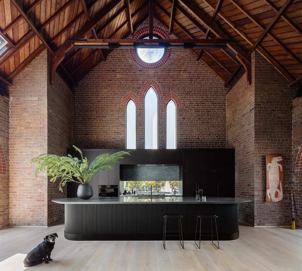 Stunning brick interior with arched windows, modern black kitchen island, and a small dog.
