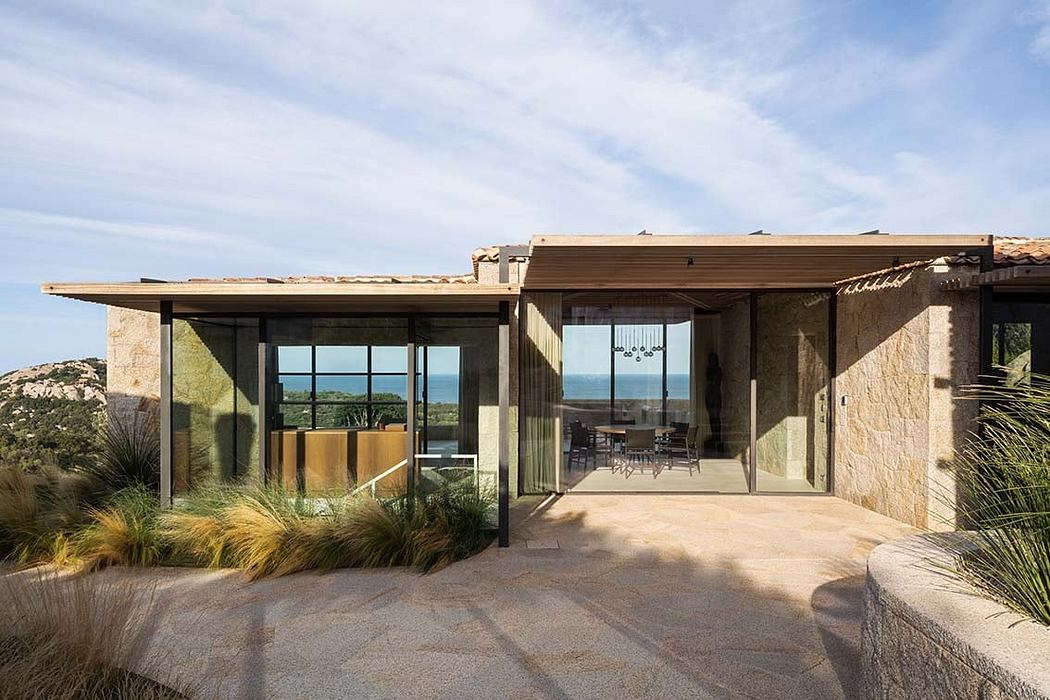Contemporary stone house with large windows and flat roof.