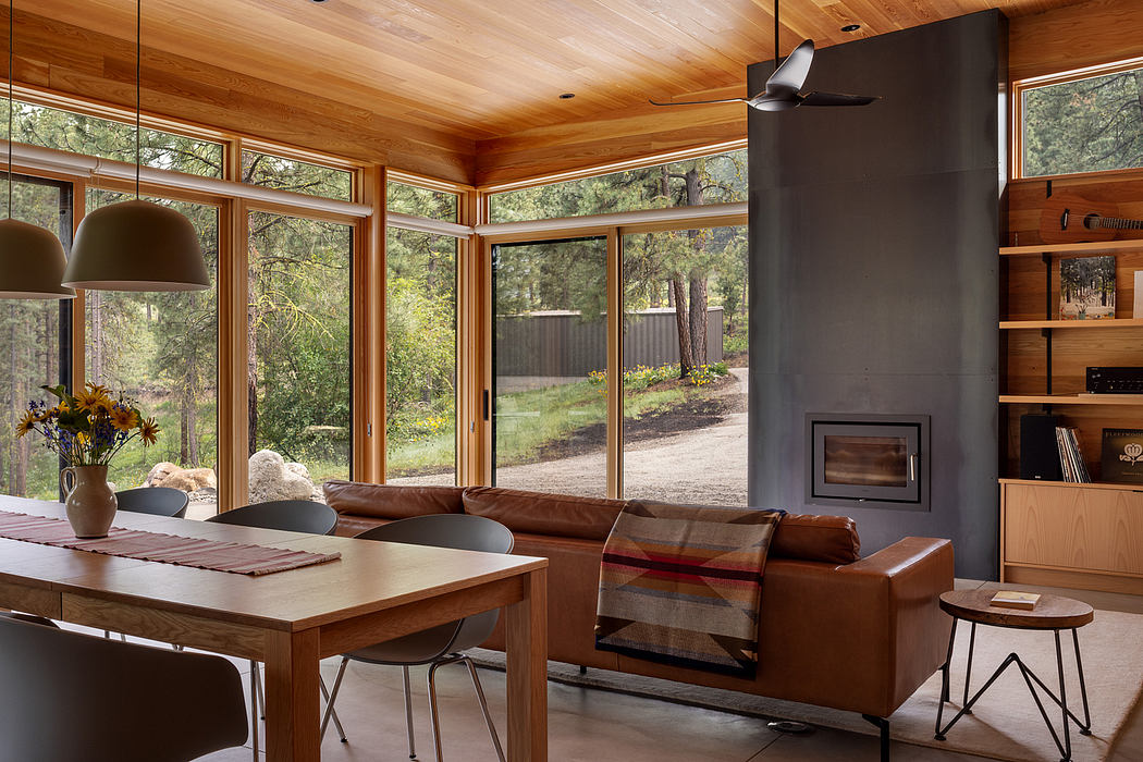 Modern living room with large windows, wooden ceiling, and a fireplace.