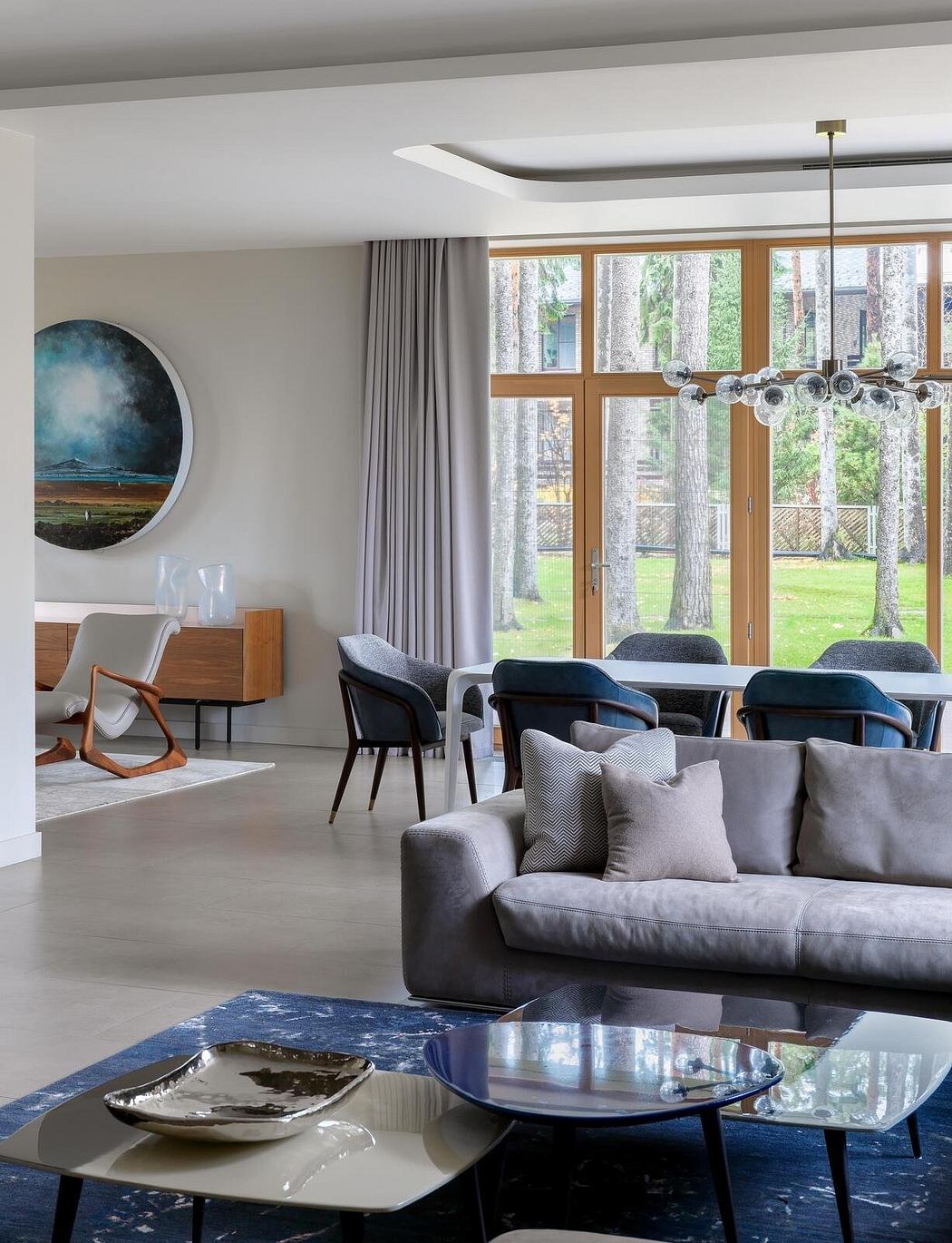 Contemporary living room with sleek furnishings, large windows, and artistic accents.