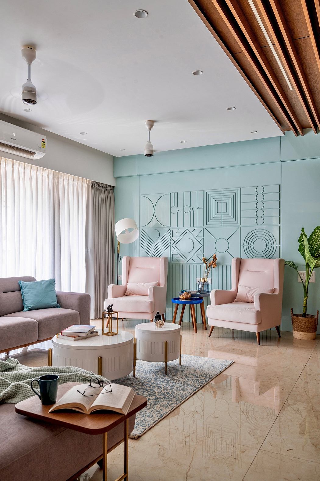 Elegant living room with geometric wall art, soft pink chairs, and wooden ceiling