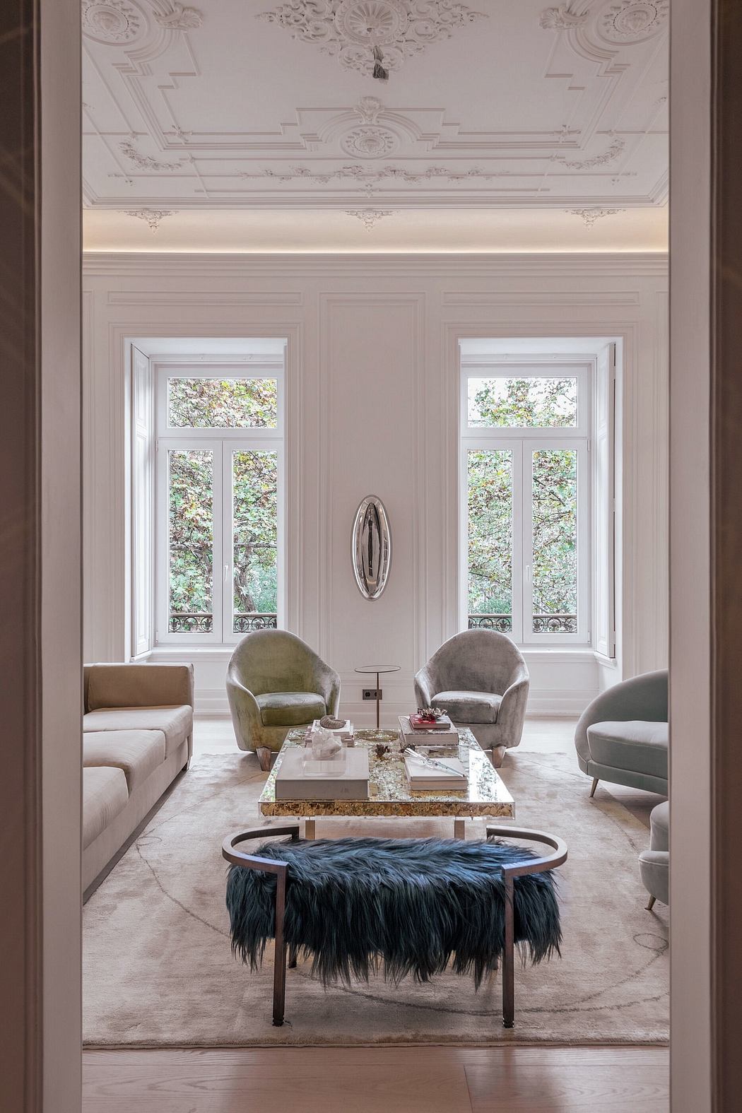 Elegant living room with ornate ceiling and chic furniture.