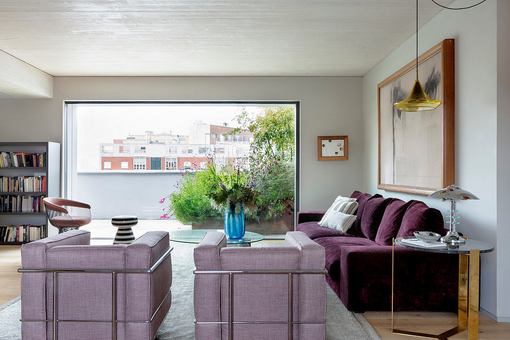 Contemporary living room with large window and plush seating.