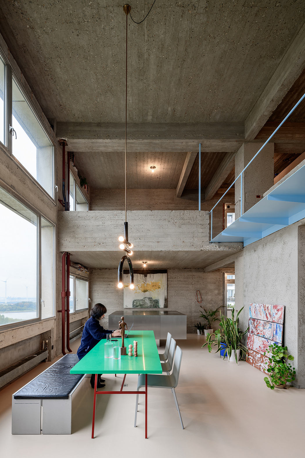 Industrial-chic dining area with exposed concrete and mezzanine.