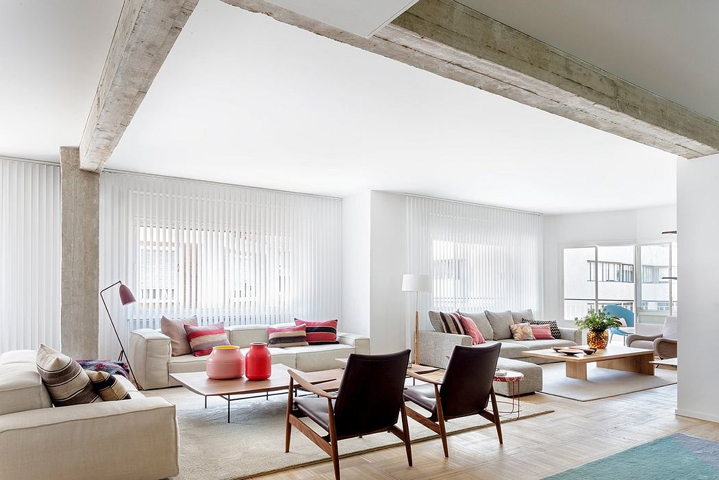 Bright, airy living space with exposed concrete beams and a mix of modern and mid-century furnishings.