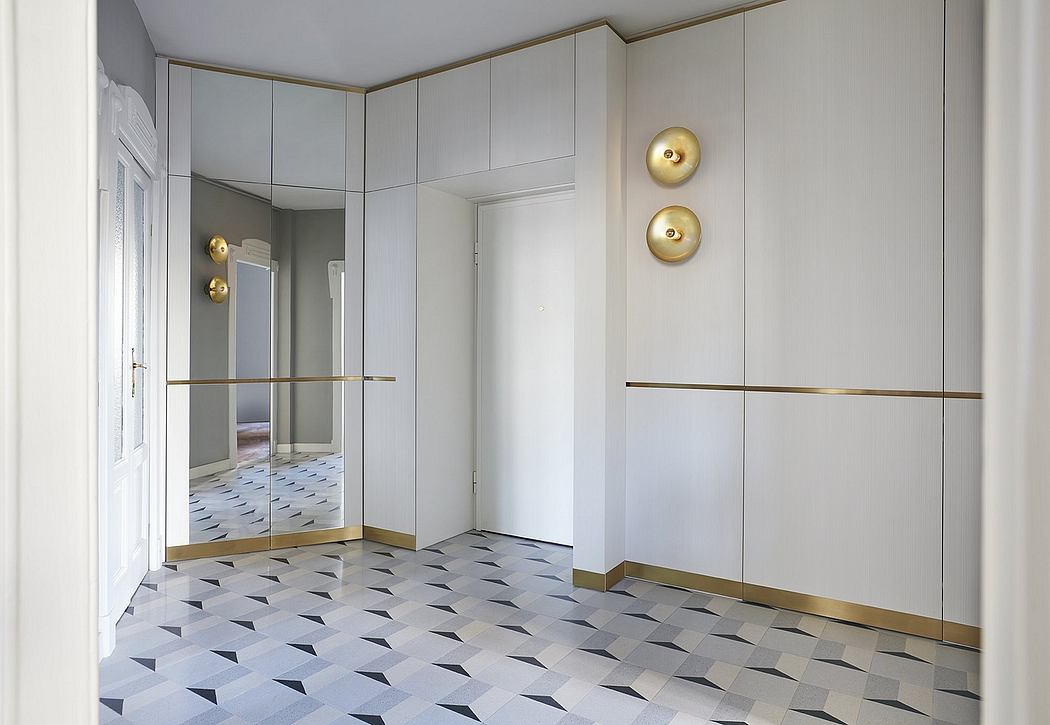 Sleek, geometric flooring and brass accents in this modern hallway design.