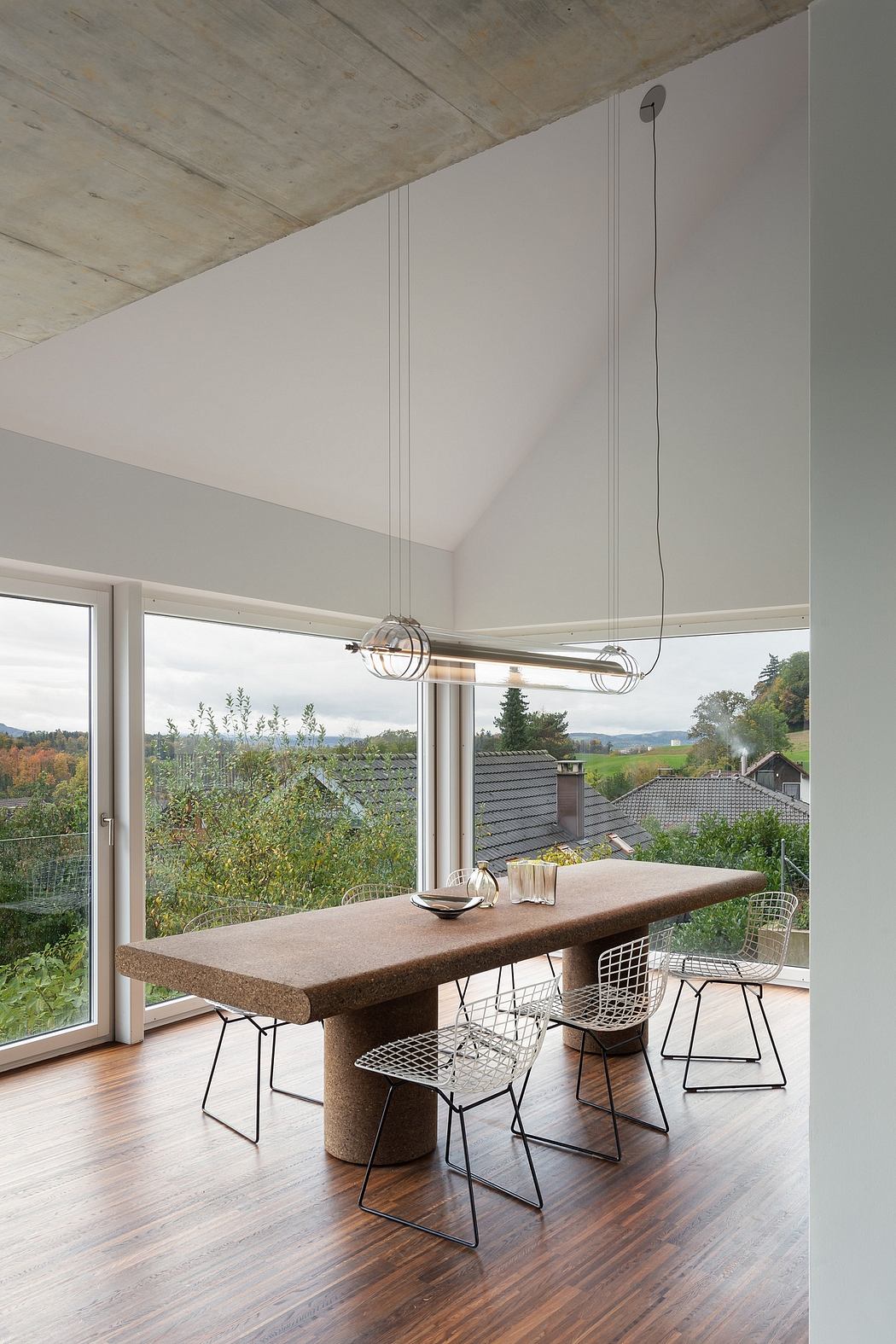 Spacious dining area with large window offering scenic countryside views, modern furniture.