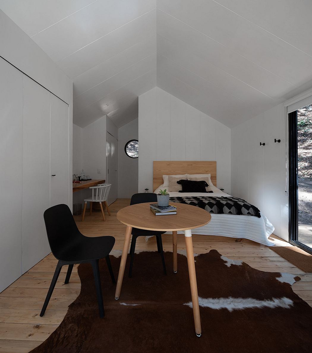 Minimalist studio apartment with wooden furniture, black accents, and a cozy atmosphere.