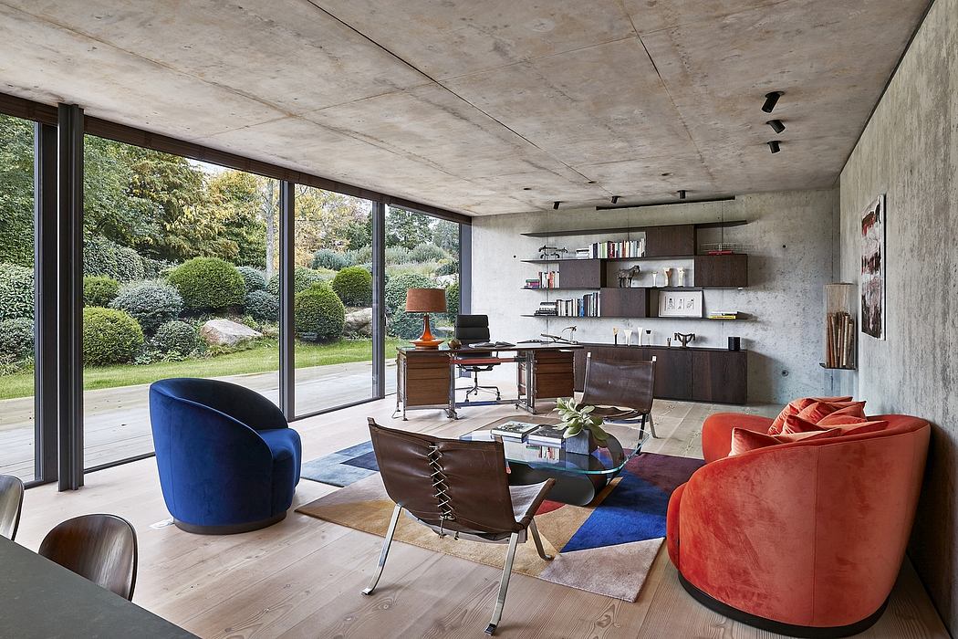Modern living room with concrete ceiling, large windows, and colorful furniture.