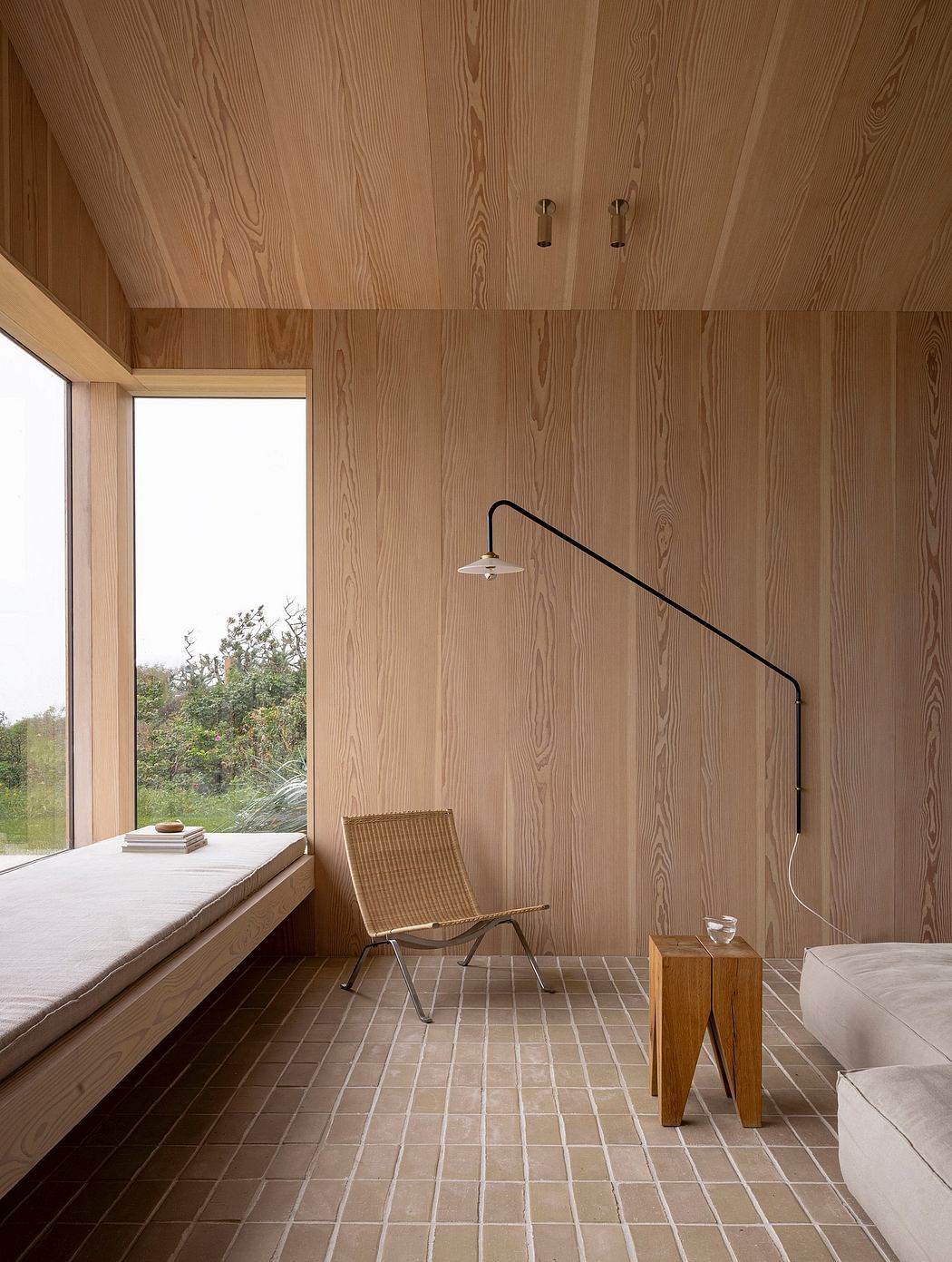 Minimalist wooden interior with simple furniture and a large window.