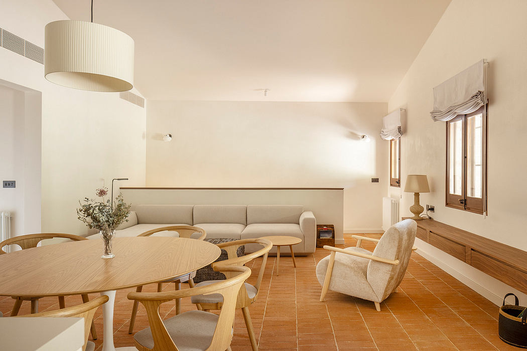 Spacious living area with wooden furnishings, large windows, and a neutral color scheme.