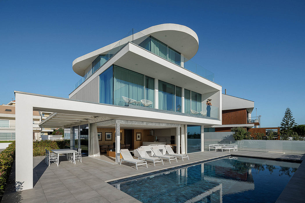 Modern architectural design with curved roof, glass walls, and an outdoor pool.