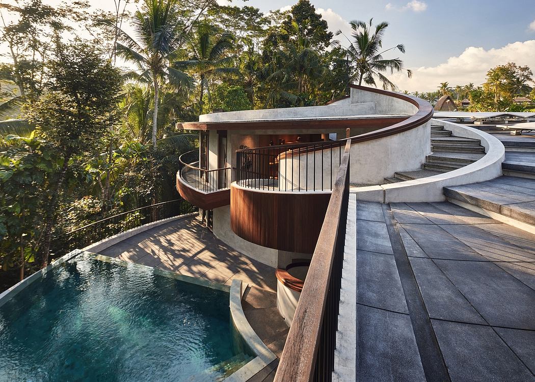 A modern, curved structure with a pool, balconies, and lush tropical greenery surrounding it.