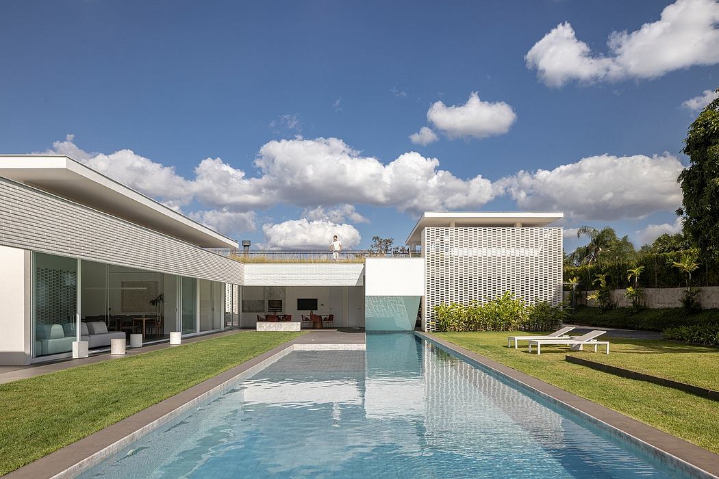 A modern luxury home with a sleek, minimalist design, a swimming pool, and lush greenery.