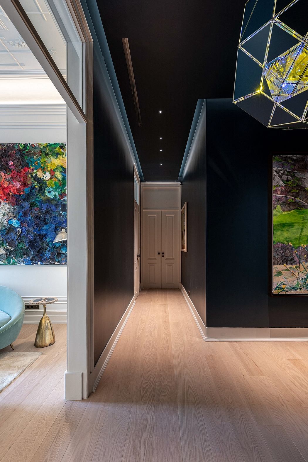 Sleek corridor with geometric light fixture and vibrant wall art.