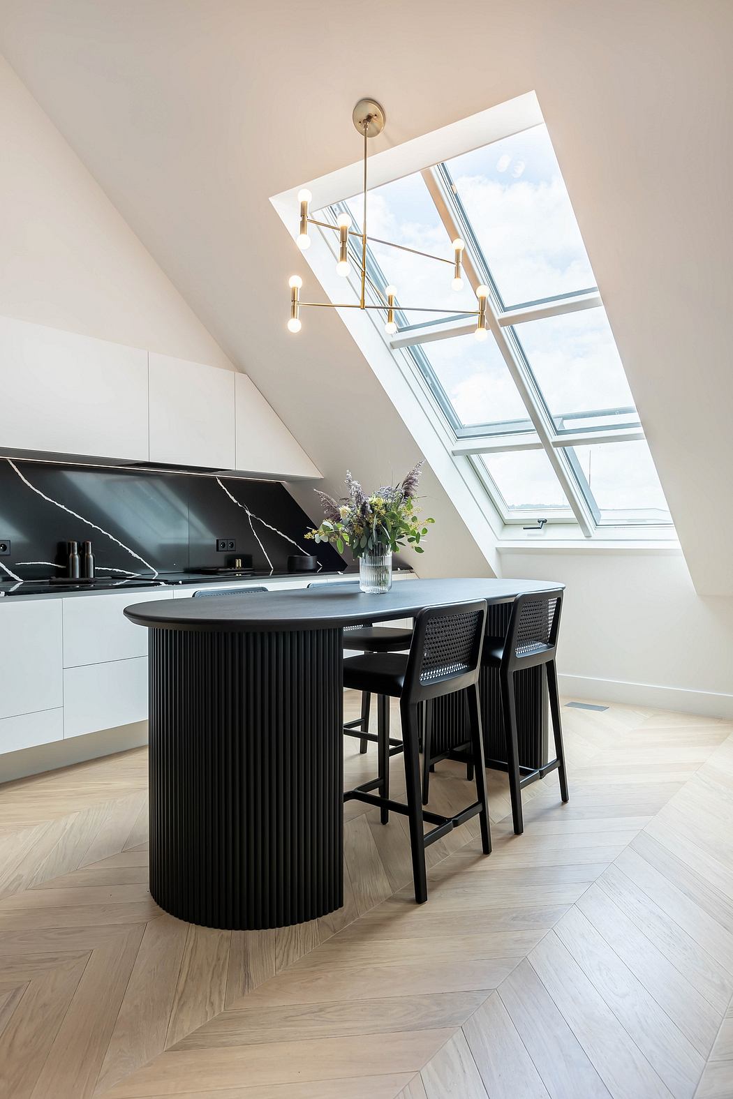 Modern kitchen with skylight, round island, and bar stools.
